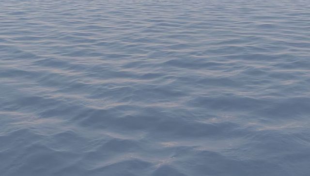 Calm Blue-Gray Expansive Ocean Surface with Gentle Ripples and Reflective Shimmer at Dusk