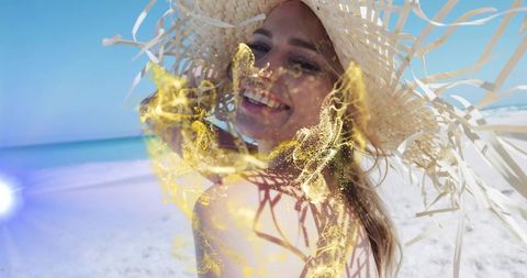 Smiling Woman on Tropical Beach Wearing Straw Hat with Golden Particles