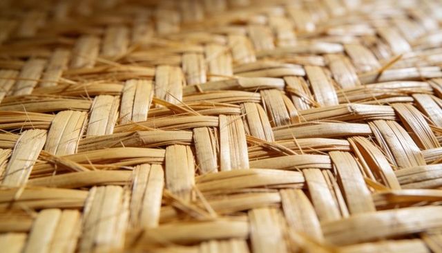 Woven natural-fiber mat revealing macro straw texture and tactile handcrafted pattern