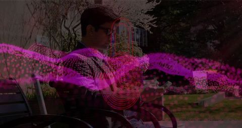 Tech-Savvy Man Sitting on Park Bench Checking Smartphone Amid Vibrant Waves