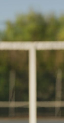 Blurry evening view of empty tennis court and spectator rail