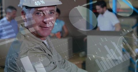 Construction manager wearing hard hat reviewing digital dashboards and analytics in office