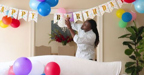 Man Decorating for Birthday Celebration with Bright Balloons