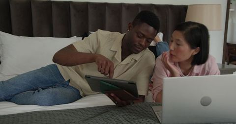 Diverse Couple Using Tablet and Laptop for Relaxation