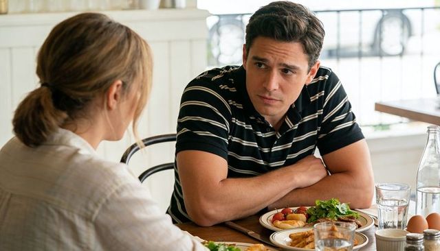 Young man leaning and listening at cafe table during serious conversation over brunch