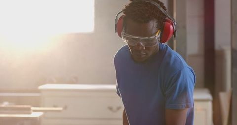 Craftsman focuses on carpentry in sunlit workshop