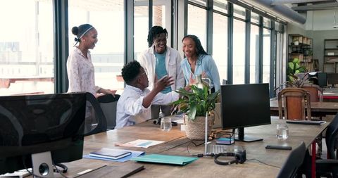 Dynamic Team Celebrating Success with Enthusiasm in Modern Workspace