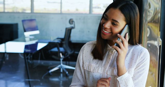 Smiling Businesswoman Talking on Phone in Modern Office Setting - Download Free Stock Images Pikwizard.com