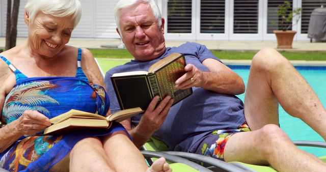 Older couple lounging by pool on sunny day, enjoying books. Ideal for lifestyle, vacation, retirement planning, senior living themes. Useful for health and wellness, leisure activities, summer fun concepts.