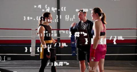 Coach Guiding Two Female Boxers in Ring During Training Session with Digital Code Overlay
