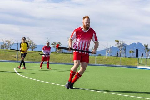 Field hockey players competing on artificial turf outdoors