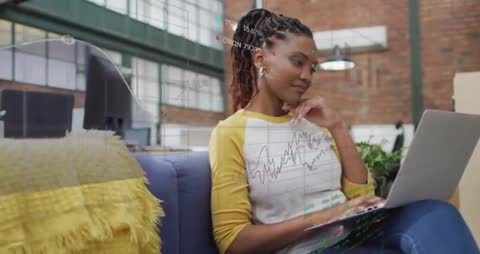 Professional Woman Analyzing Financial Data on Laptop in Modern Office Lounge