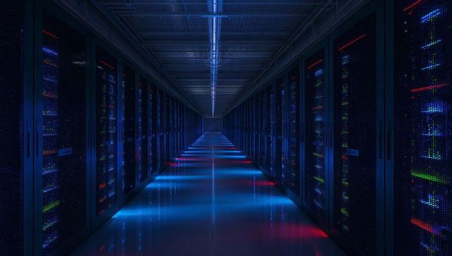 Glowing data center aisle stretching into distance reflecting blue red LED server lights