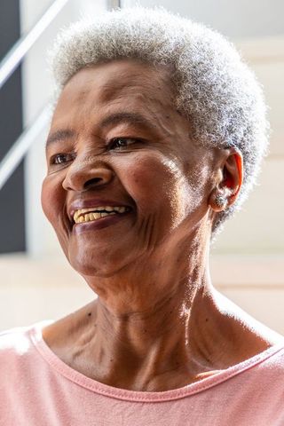 Senior african american woman smiling in natural light with gray hair and warm expression