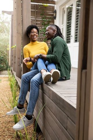 African american couple laughing on porch in rustic outdoor scene