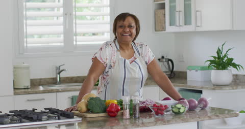 Senior Woman Enjoying Cooking with Fresh Vegetables in Modern Kitchen