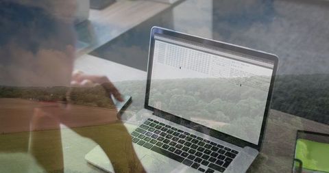 Woman Coding on Laptop in Home Office with Scenic Rural View