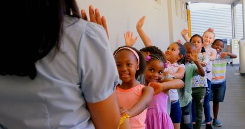 Joyful Schoolchildren Waving in Corridor Queue - Download Free Stock Images Pikwizard.com