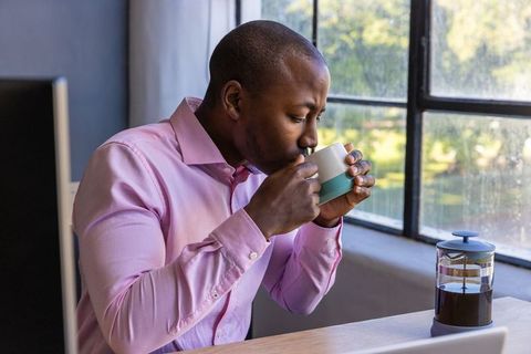 Businessman Enjoying Coffee Break by Sunlit Office Window