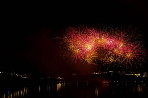 Stunning Fireworks Exploding Over Calm Night River