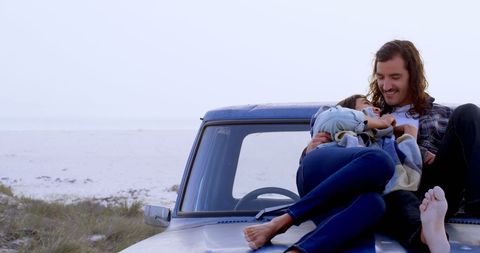 Couple Enjoying Beach Relaxation Sitting on Pickup Truck