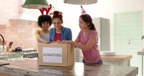 Diverse friends organizing donations in modern kitchen for charity