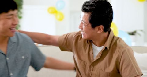 Asian men enjoying birthday celebration at home