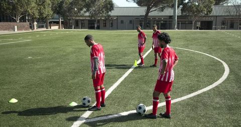 Young soccer players training on field