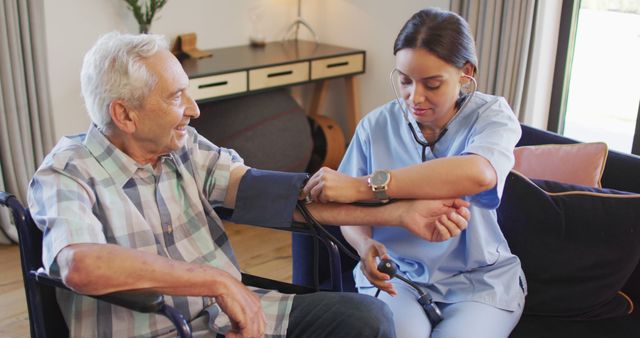 Image of biracial female doctor checking pressure to caucasian senior man. seniors health and nursing home lifestyle concept digitally generated image.