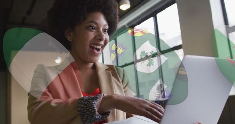Enthusiastic African American Intern Using Laptop in Modern Office
