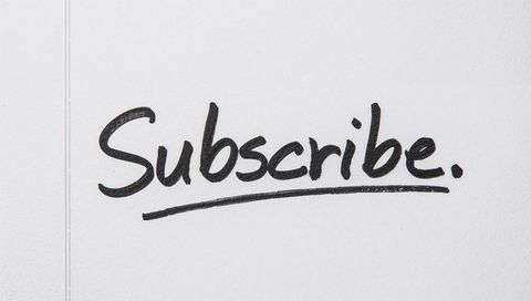 Handwritten subscribe underlined on textured white paper clean social media call-to-action