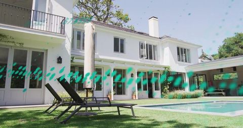 Modern white two-story home with backyard pool, lounge chairs, glass patio and balcony