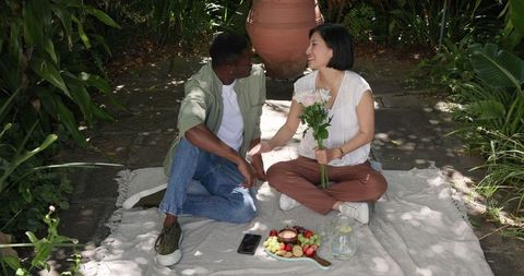 Romantic couple enjoying outdoor picnic in garden setting