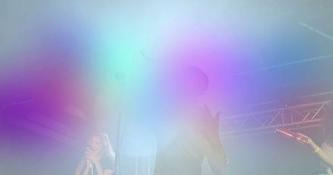 Energetic Band Performance on Stage with Colorful Haze