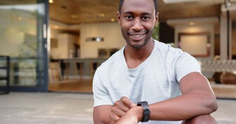 Man Relaxing on Patio Checking Fitness Watch