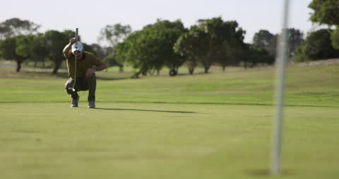 Golfer Focusing on Putt on Lush Green Course