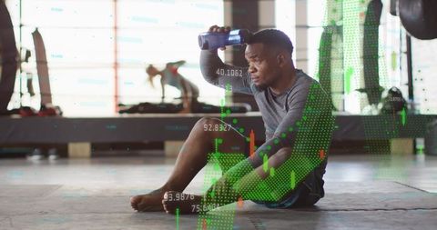 Tired man resting on gym floor hydrating with fitness analytics and market chart overlay