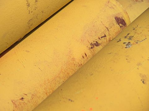 Weathered Yellow Metal Pipe Texture with Rust Marks and Chipped Paint for Industrial Use