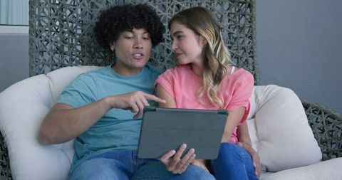 Young Couple Discussing Content on Tablet on Cozy Sofa