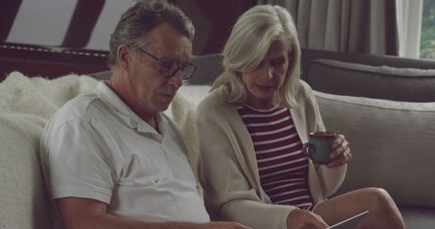 Senior Couple Reviewing Documents at Home with Serious Focus