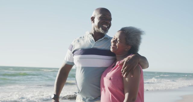 Senior couple embracing on beach, enjoying retirement by the sea. This can be used for themes relating to retirement, joy, companionship, senior lifestyle, and travel. Ideal for advertising retirement planning, travel agencies, resort promotions, and healthcare services focusing on older adults.