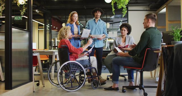 Happy disabled and diverse business people discussing work at office. Work at a modern office.
