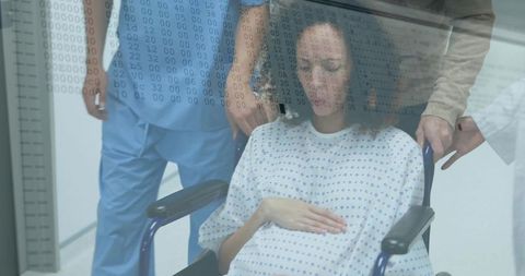 Female patient resting in wheelchair while nurse and caregiver provide support