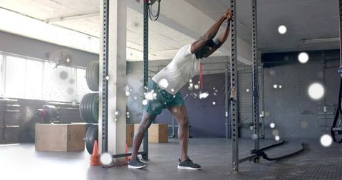 Male Athlete Stretching in Modern Gym Filled with Light