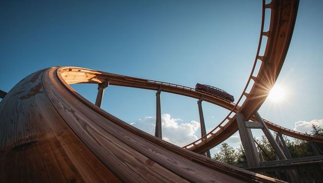 Exciting wooden roller coaster against blue sky