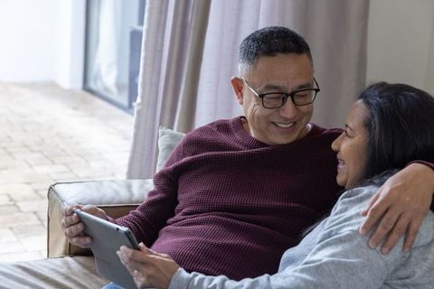 Senior Couple Using Tablet on Cozy Living Room Couch