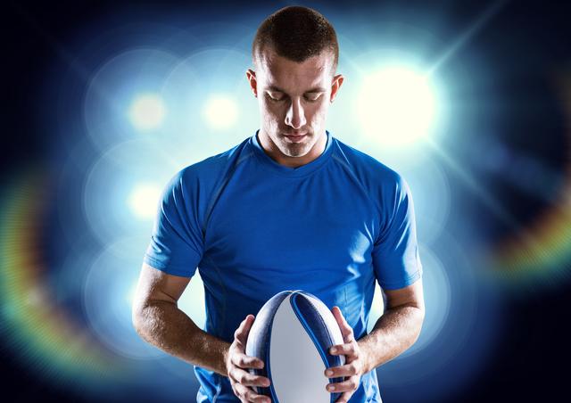 Rugby player holding ball against illuminated background - Download Free Stock Photos Pikwizard.com