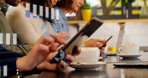Group tapping smartphones and tablet at cafe counter with cappuccinos and digital ui overlay