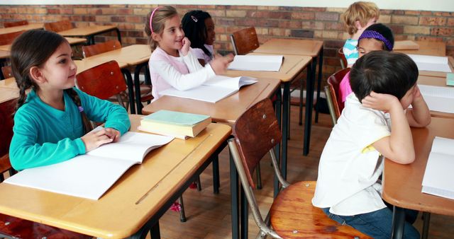 Young Children Learning in Classroom with Books on Desks - Download Free Stock Images Pikwizard.com