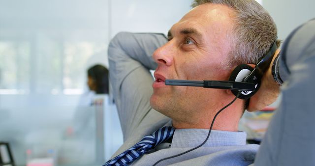 Relaxed Customer Service Representative Wearing Headset at Office Desk - Download Free Stock Images Pikwizard.com